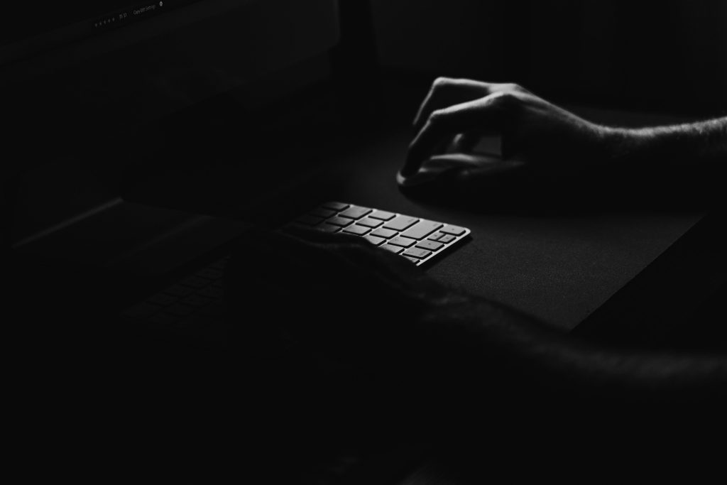 Hand reaching for a computer mouse and keyboard in a dark room — masturbation shame reclamation essay, 49Grey