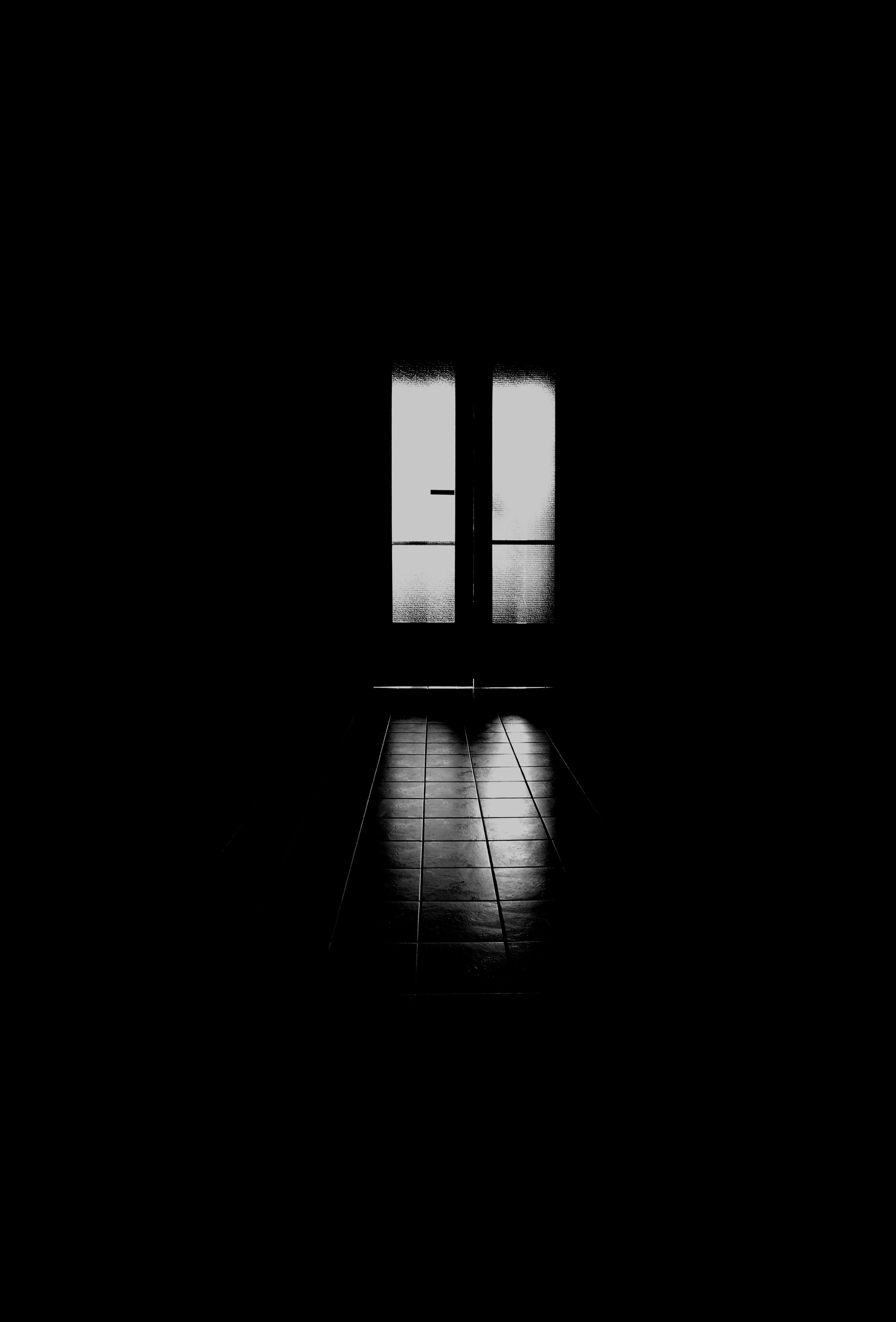 Dark hallway leading toward an open door with light spilling in. Kink curious beginners essay, 49Grey